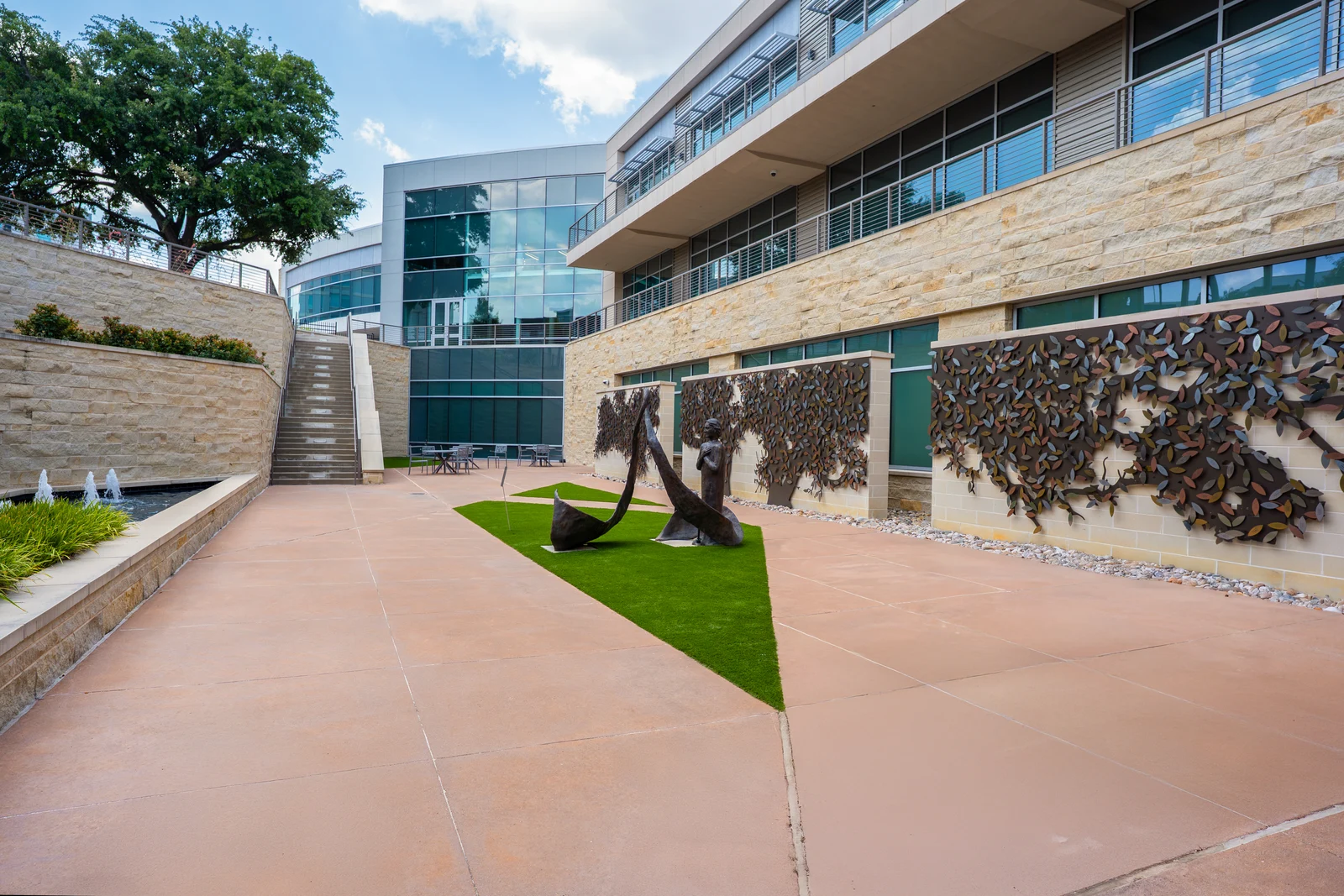 The Dallas Donor Memorial Garden courtyard with the Tree of Remembrance’s engraved-leaf memorial walls, sculpture, and fountain.