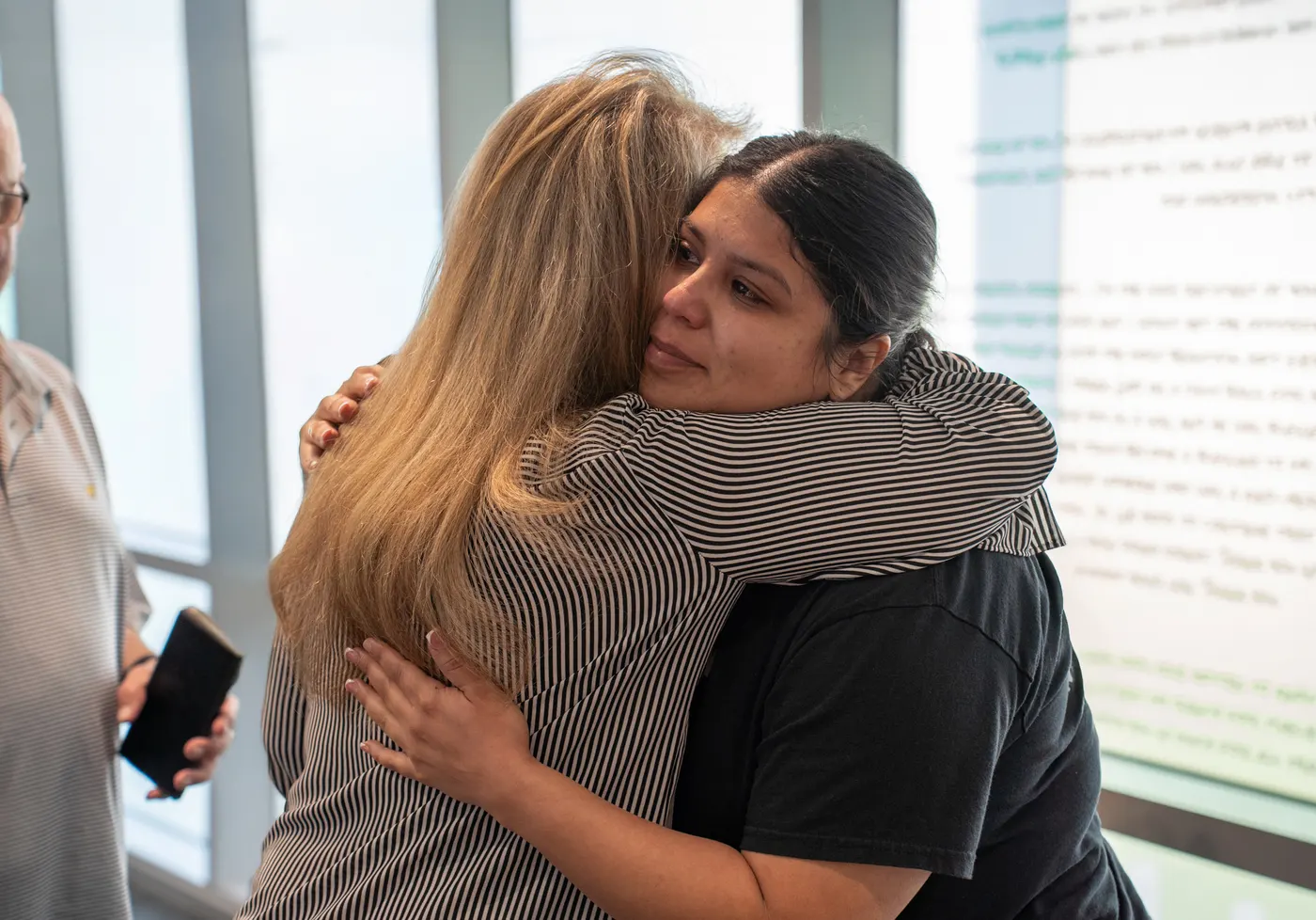 Two women share a warm, close embrace.